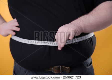 The Big Man Makes Measurements With The Tape Of His Fat Stomach.