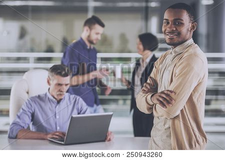 African American With Colleagues In Office. Young Smiling Businessman With Crossed Hands. Business P