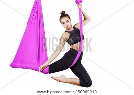 Young Woman Doing Aerial Yoga Exercise Or Antigravity Yoga On A White Isolate. Flying, Fitness, Stre