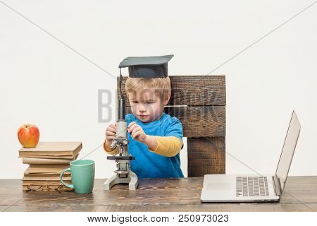 Concentrated Boy With Microscope. Wunderkind Concept. Smart Small Kid, Scientist Child Works With Mi