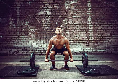 Muscular Fitness Man Doing Deadlift A Barbell Over His Head In Outdoor, Street Gym.. Functional Trai