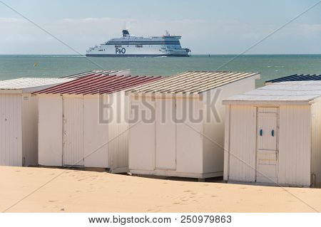 Calais, France - 19 June 2018: Beach Cabins And P&o Cross Channel Ferry On Its Way To The Port.