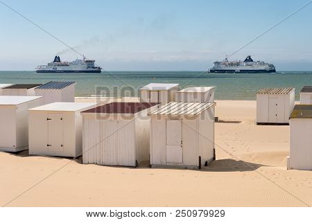Calais, France - 19 June 2018: Beach Cabins And Dfds / P&o Cross Channel Ferries.