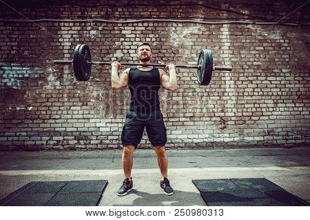 Muscular Fitness Man Doing Deadlift A Barbell Over His Head In Outdoor, Street Gym. Functional Train