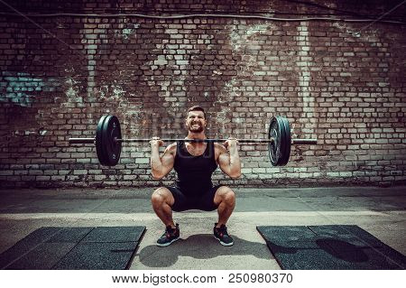 Muscular Fitness Man Doing Deadlift A Barbell Over His Head In Outdoor, Street Gym. Functional Train