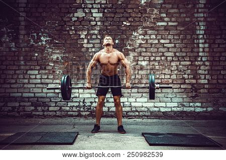 Muscular Fitness Man Doing Deadlift A Barbell Over His Head In Outdoor, Street Gym. Functional Train