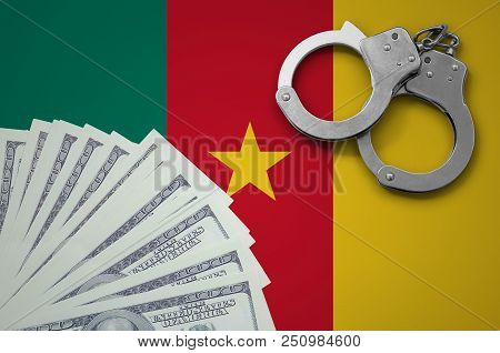Cameroon Flag  With Handcuffs And A Bundle Of Dollars. The Concept Of Illegal Banking Operations In 