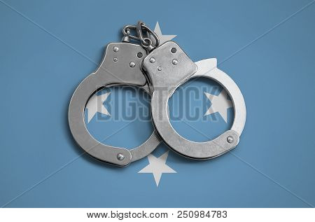 Micronesia Flag  And Police Handcuffs. The Concept Of Observance Of The Law In The Country And Prote