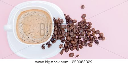 Grains Of Roasted Coffee Scattered From A Cup On A Pink Background, Copy Space. Top View.