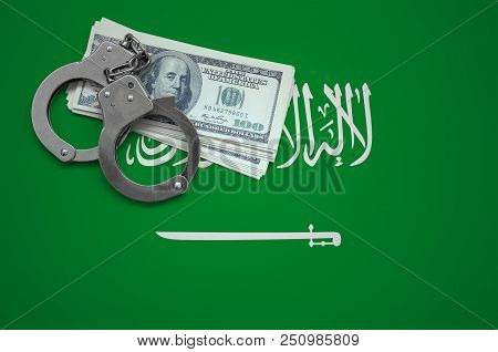 Saudi Arabia Flag  With Handcuffs And A Bundle Of Dollars. The Concept Of Breaking The Law And Thiev