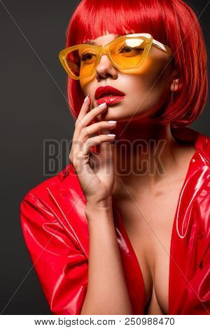 Close-up Portrait Of Beautiful Young Woman In Red Latex Jacket On Bare Skin And Vintage Yellow Sungl