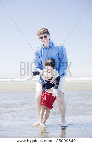 Padre figlio disabile a piedi alla spiaggia