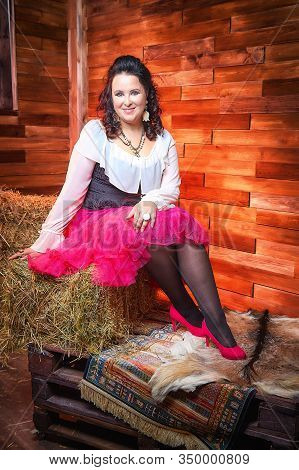 Portrait Of Fat Plump Fun Charming Cute Woman With Black Curly Hair In The Room With Hay And Straw