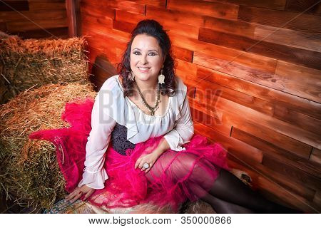 Portrait Of Fat Plump Fun Charming Cute Woman With Black Curly Hair In The Room With Hay And Straw