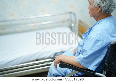 Asian Senior Or Elderly Old Lady Woman Patient Sitting On  Wheelchair With Bed At Nursing Hospital W