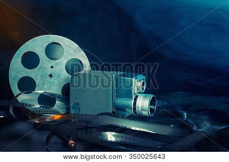 8 Mm Movie Camera With A Reel Of Film In Smoke. Dark Background