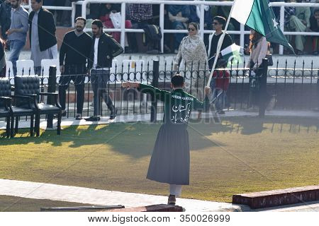 Wagah, Pakistan - Febuary 8, 2020: Pakistani Performer Man Holds A Flag And Hypes Up The Crowd Befor