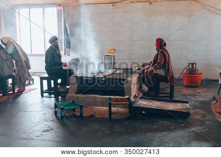 Amritsar India - Febuary 8, 2020: Sikh Man And Indian Woman Prepare Chapati - Traditional Indian Bre