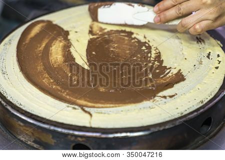 Cooking Thai Pancakes: The Cook Carefully Smears And Spreads The Chocolate Paste On Pancakes That Ar
