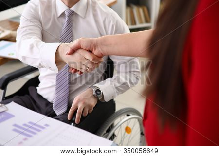 Disabled Man In A Shirt And Tie Shakes Hands With His New Boss Who Hired Him Closeup. Adaptation Of 