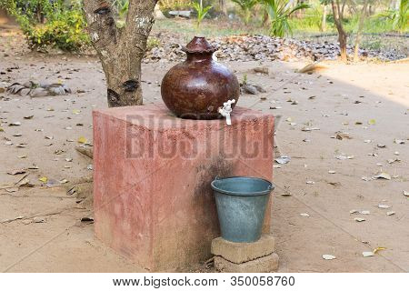 Earthenware Pot Hand Made And Used For Holding Drinking Water With Plastic Bucket For Collecting Dri