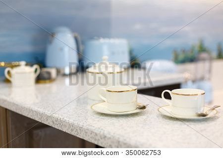 Beautiful set with cups on the bar counter. Background in blur. With household appliances