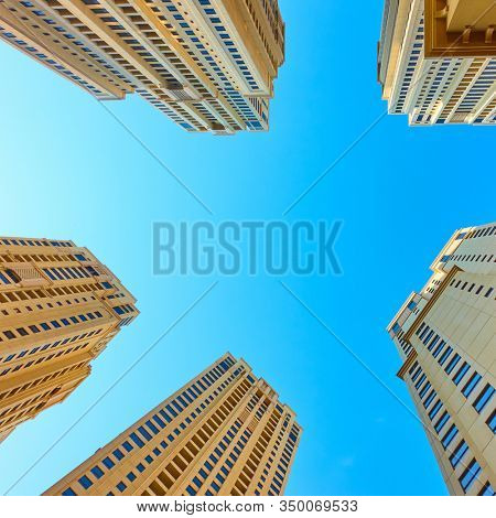 Angle shot of modern apartment buildings against the clear blue sky