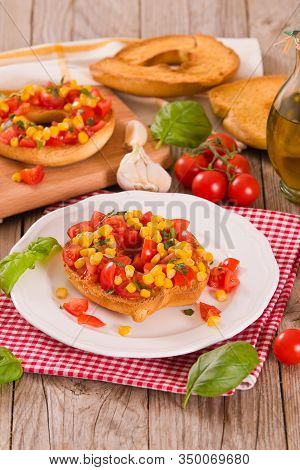 Friselle With Tomatoes And Mais On White Dish.
