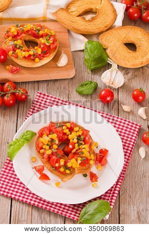 Friselle With Tomatoes And Mais On White Dish.
