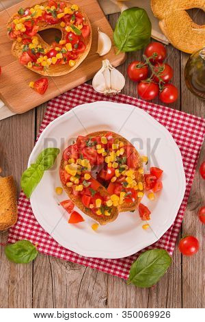 Friselle With Tomatoes And Mais On White Dish.