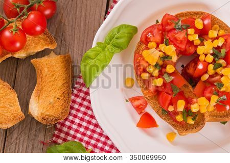 Friselle With Tomatoes And Mais On White Dish.