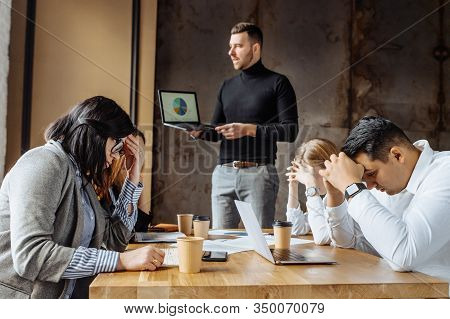 Troubles At Work. Bad Period For Company Employees, Bad Reports. A Team Of Young People Sit At A Tab