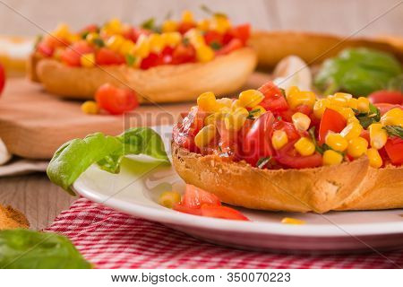 Friselle With Tomatoes And Mais On White Dish.