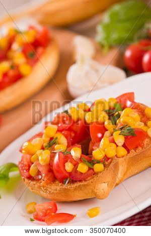 Friselle With Tomatoes And Mais On White Dish.