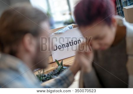 Man Calming A Crying Young Girl At A Charity Center.