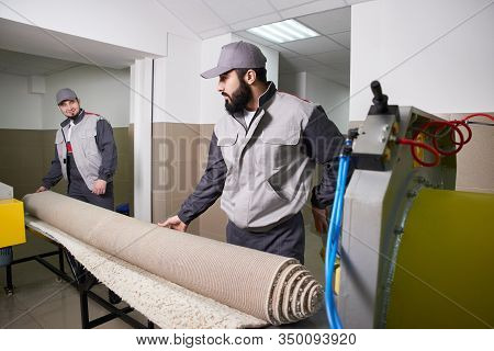 Men Workers Get Carpet From An Automatic Washing Machine And Put In In Dryer In The Laundry Service
