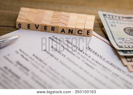 Severance Pay Concept With Agreement Document On Wooden Board And Severance Spelled Out In Wood Bloc