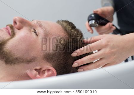 Close-up Of A Male Hair Care Master Washing A Mans Head In A Sink After Cutting His Hair