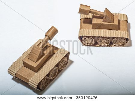 Two Toy Tanks Made By Children From Corrugated Cardboard Are Fighting. Toy Cardboard Tanks Isolated 