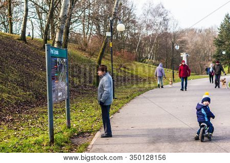 Poznan, Poland - February 9, 2020: Older Man Looking At A Information Board And Map By A Footpath In