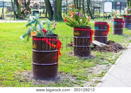 Poznan, Poland - February 9, 2020: Row Of Metal Containers With Pine Tree Twigs And Decorations On G