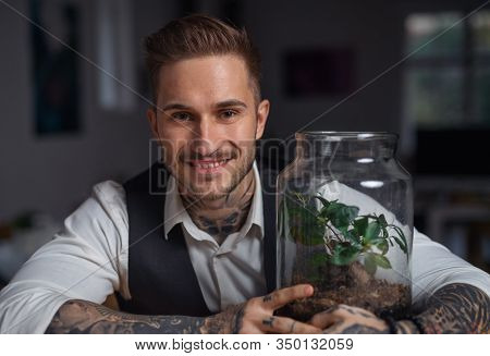 A Businessman With Plant Terrarium Sitting At The Desk Indoors In Office.