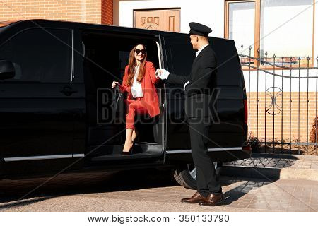 Professional Driver Helping Businesswoman To Get Out Of Car. Chauffeur Service