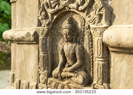 Ancient Carved Stone Pillar With The Image Of A Sitting Buddha And Are Decorated With Traditional Bu