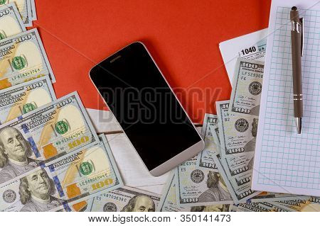 Tax Retrun Check With 100 Dollar Bills Usa Currency And Spiral Notepad Cellphone