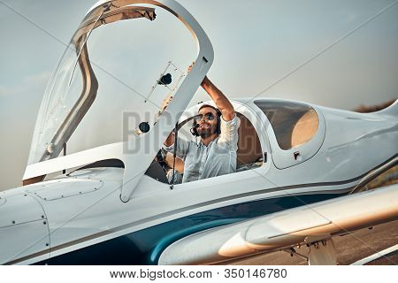 Pilot Closing Light Aircraft Cockpit At Small Airport