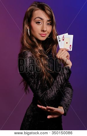 Brunette Girl In Black Velvet Dress Showing Two Playing Cards, Posing Sideways On Coloful Background