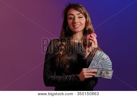 Brunette Girl In Black Velvet Dress Showing Two Red Chips And Some Cash, Posing Against Coloful Back