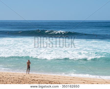 Many Surfers Waiting For Big Wave In The Sea At Banzai Pipeline On North Coast Of Oahu, Hawaii