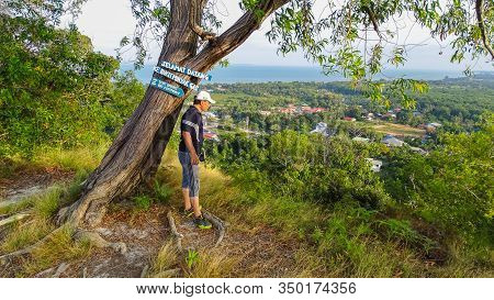 Labuan,malaysia-feb 1,2020:a Hiking Man Is Standing On The Top Of Hill & Looking To The Landscape In